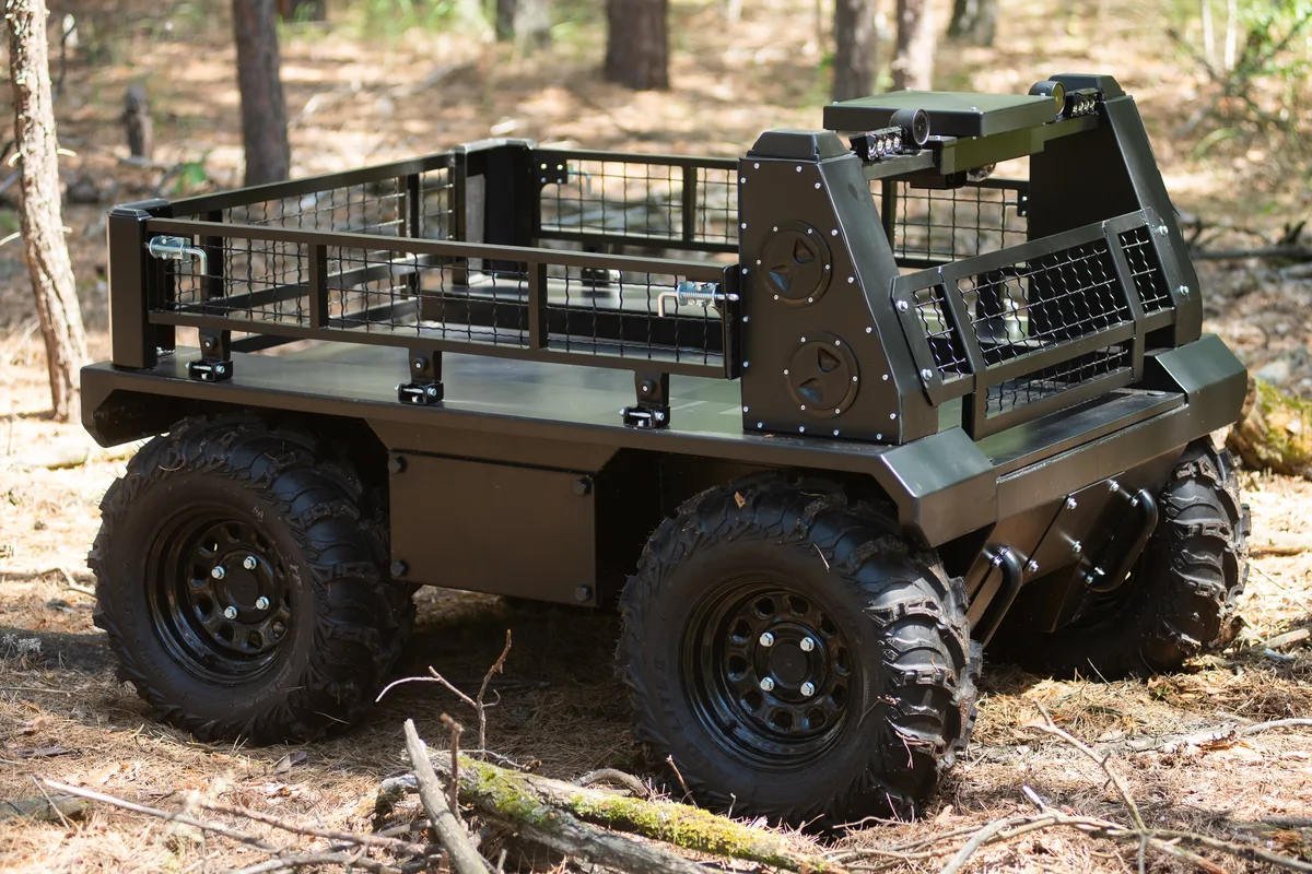Albion wheeled logistics robot with a cargo cage in a pine forest