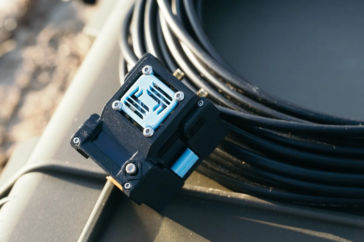 X61.TX transmitter module on an equipment case beside a coiled cable