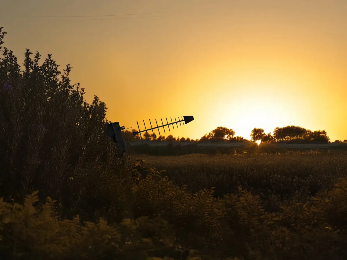 Damba electronic-warfare antenna silhouetted against a sunset