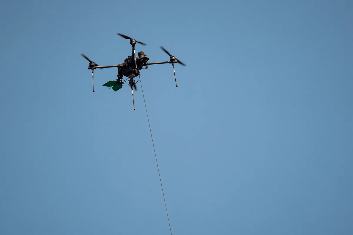 Highline-T tethered quadcopter in flight against a blue sky