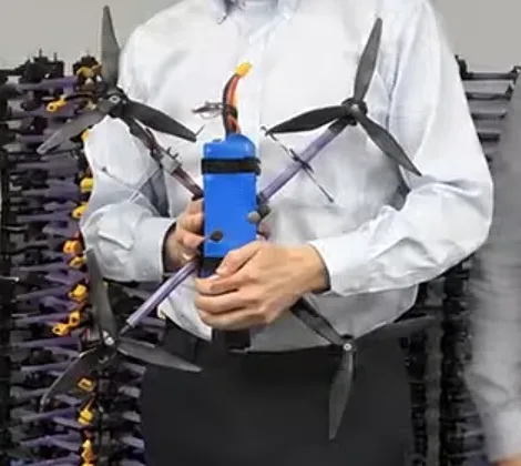 Kurin KT interceptor quadcopter held in front of racks of drones