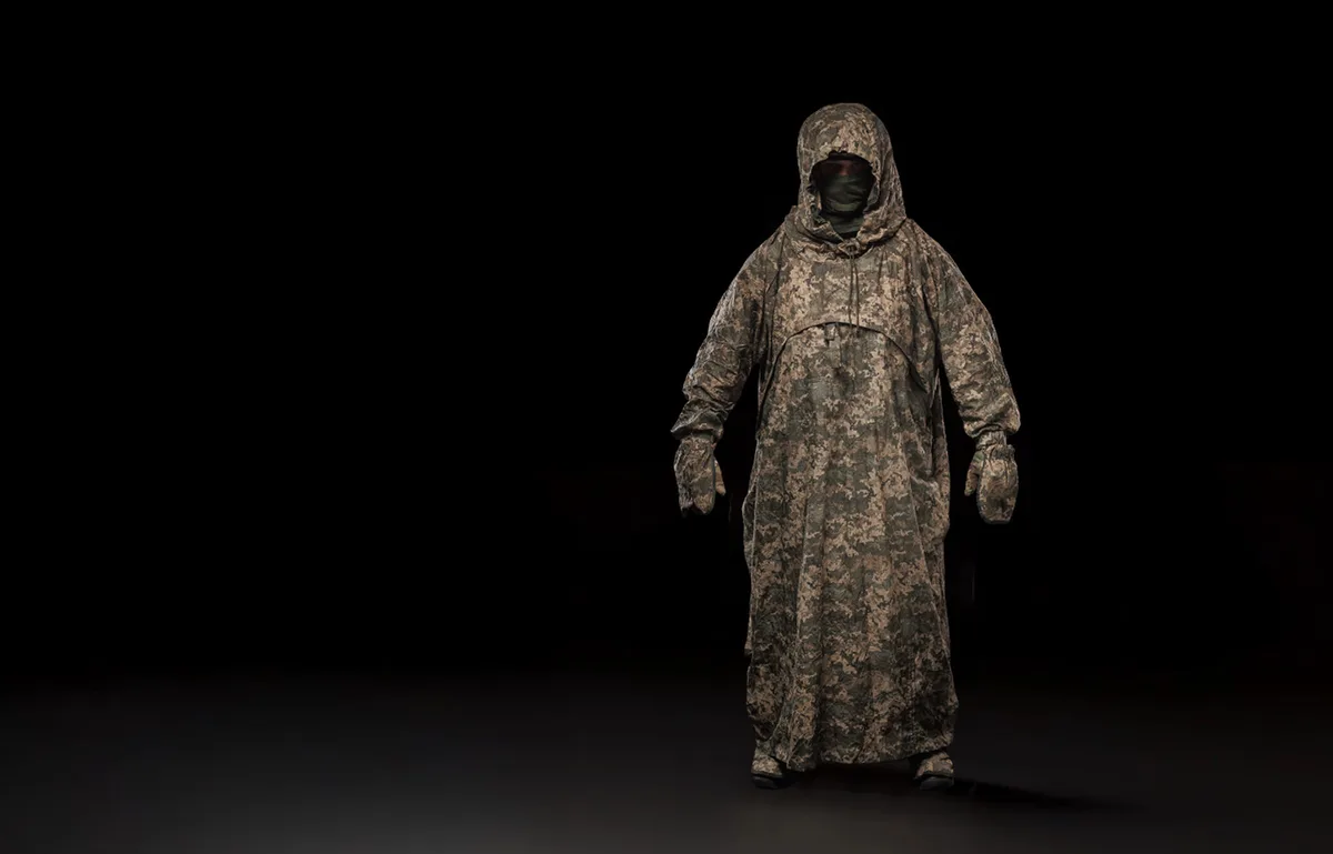 Soldier wearing the anti-thermal camouflage poncho on a black background