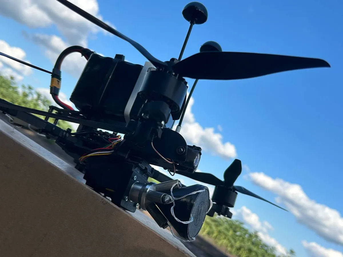 WinFly interceptor quadcopter with a net launcher, seen from below against the sky